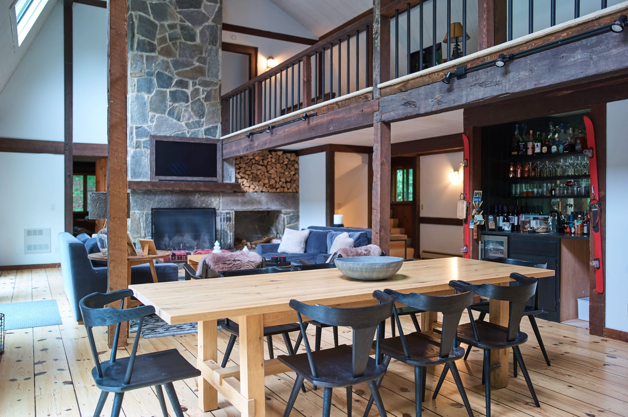 Dining table and lounge seating at Apres Lodge, a timber-frame ski lodge in Winhall, Vermont