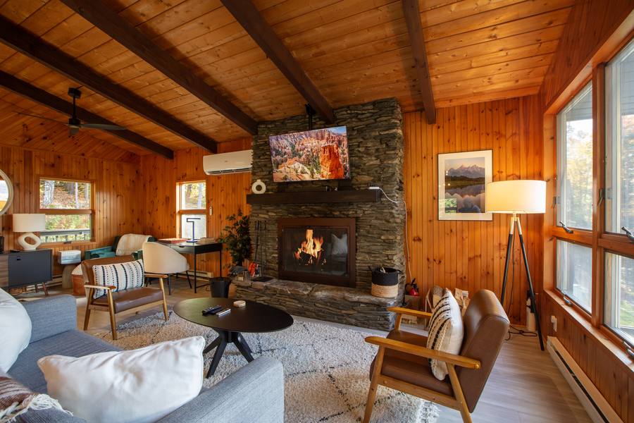 Stratton Chalet living room with a stone fireplace and wood-panelled walls