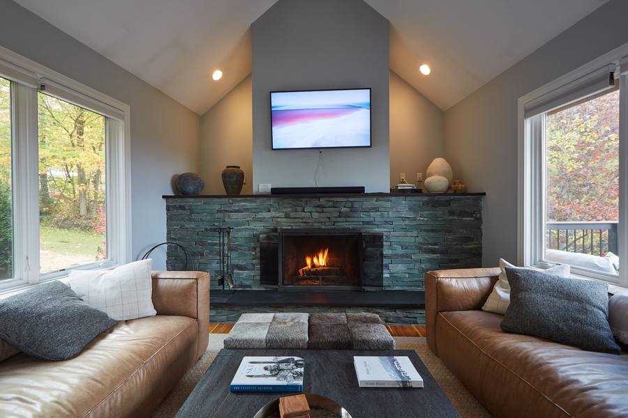 Whispering Pines Lodge living room with a stone fireplace and mountain-view windows