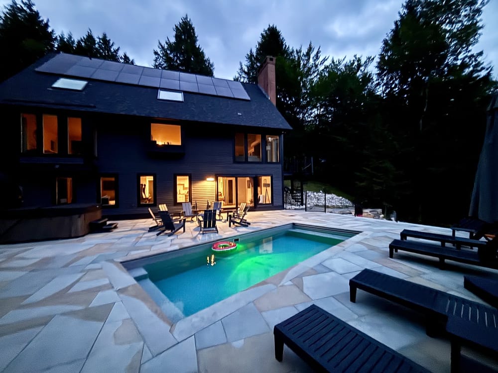 Wandering Moose at dusk with its heated pool lit and the house windows glowing
