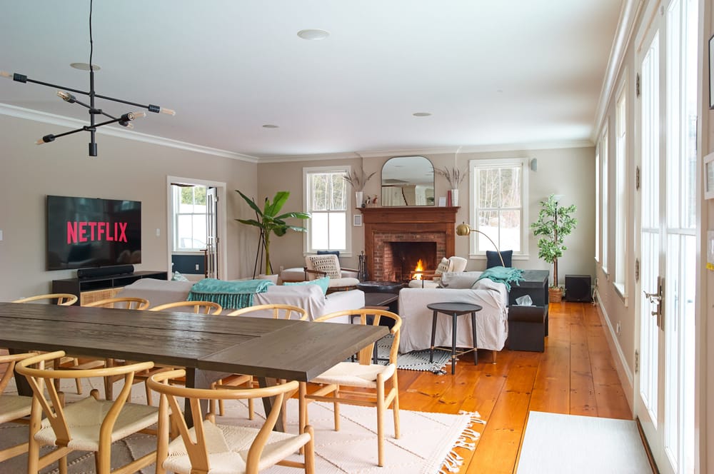 Open-plan living and dining room at Mellow Moose in Londonderry, Vermont, with a wood-burning fireplace