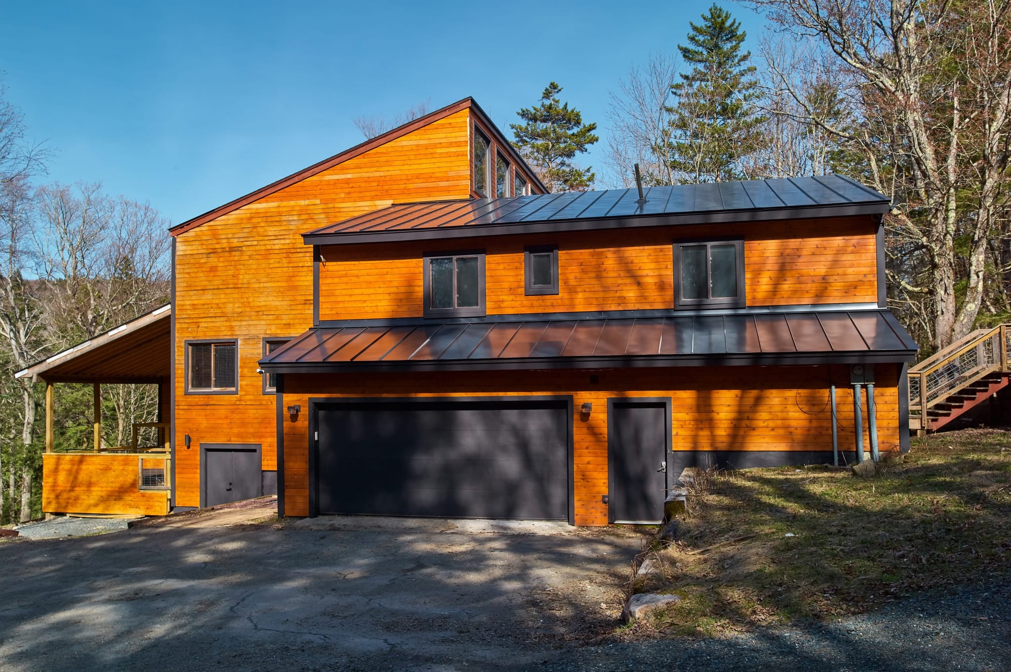 Hooks Lodge, a modern cedar-clad vacation rental in Dover, Vermont with solar panels and a standing-seam metal roof