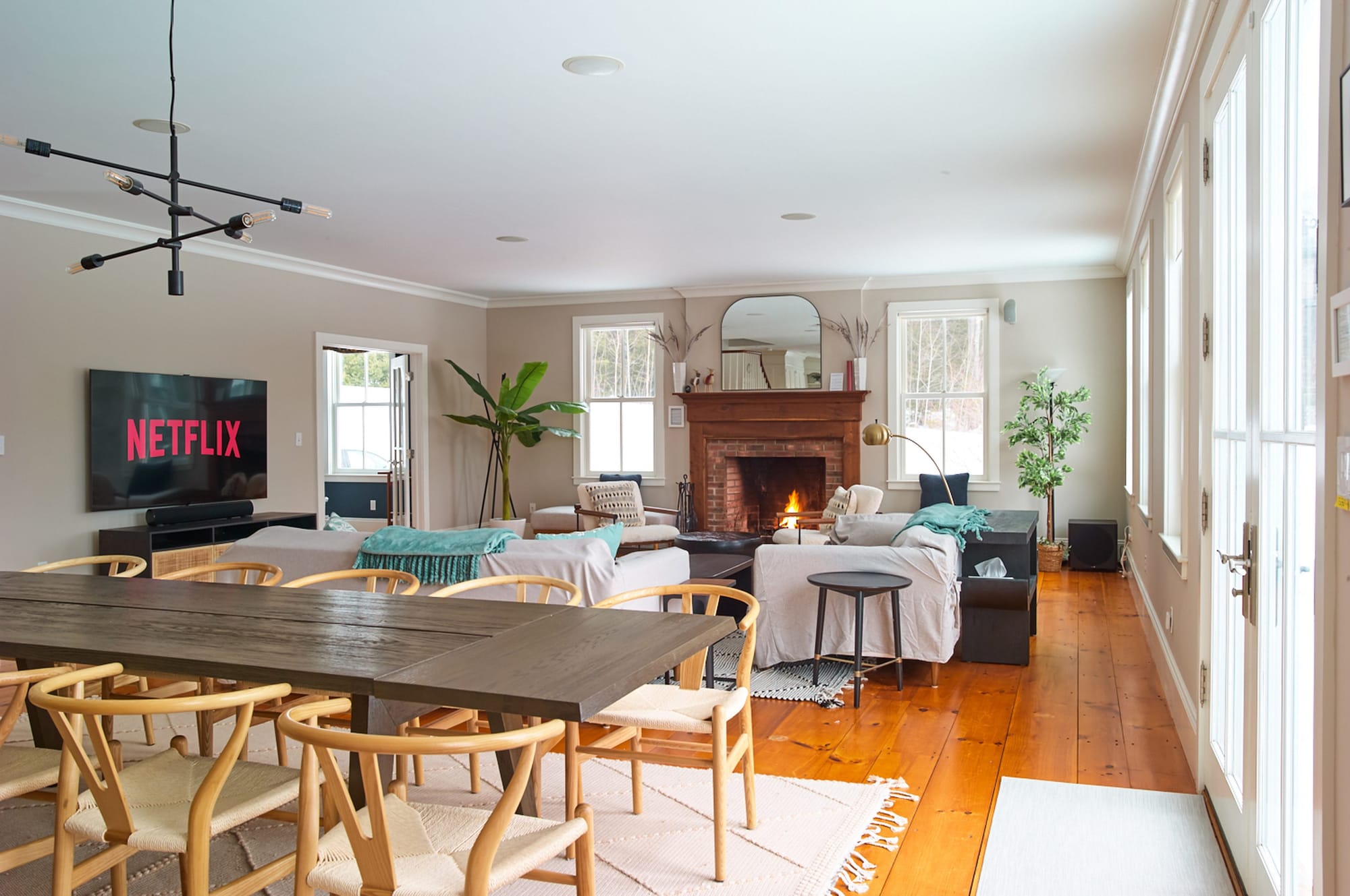 Open-plan living and dining room at Mellow Moose in Londonderry, Vermont, with a wood-burning fireplace
